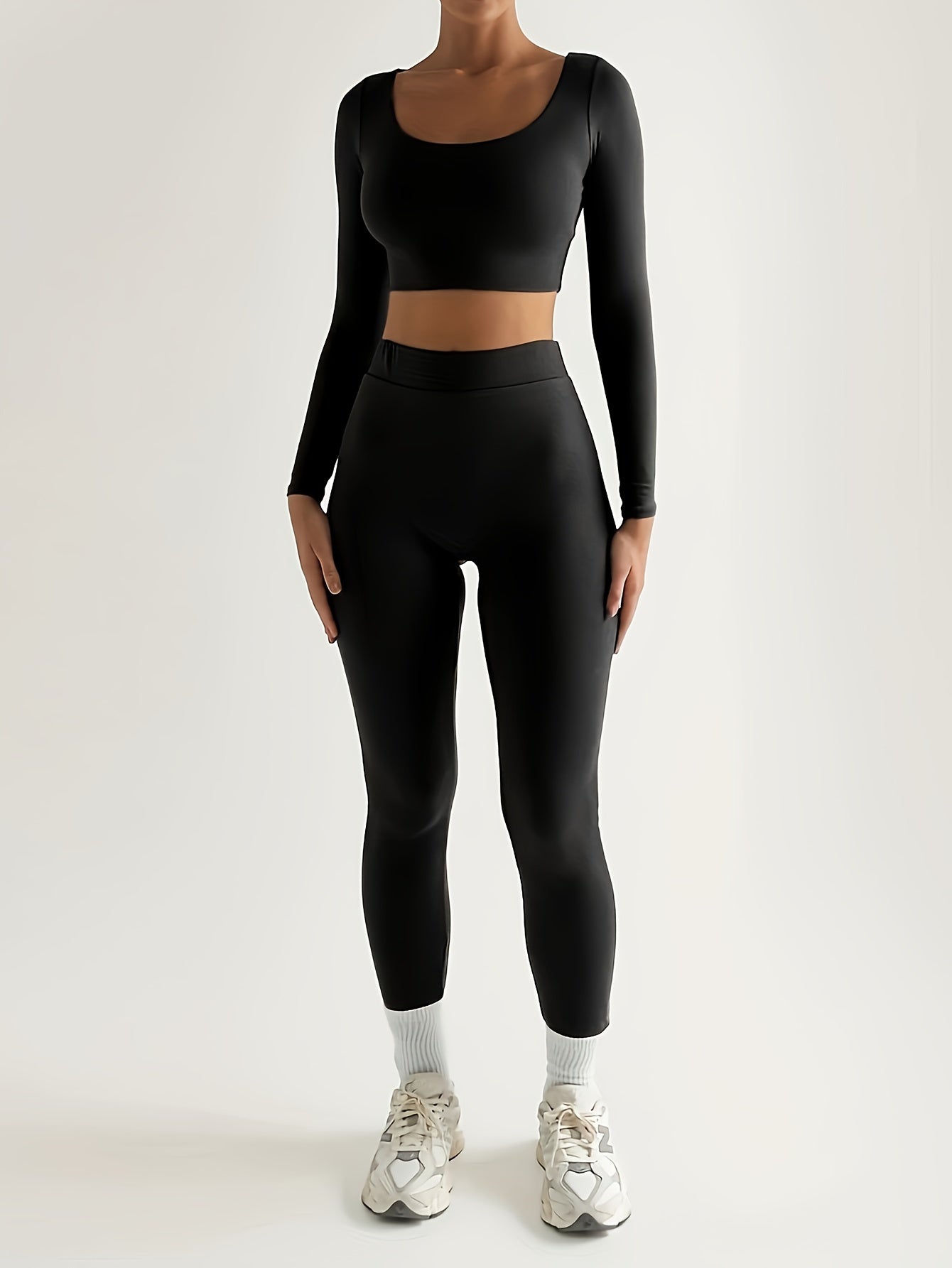 Sportset som bestå r av en lå ngärmad crop top och smala byxor med hög midja