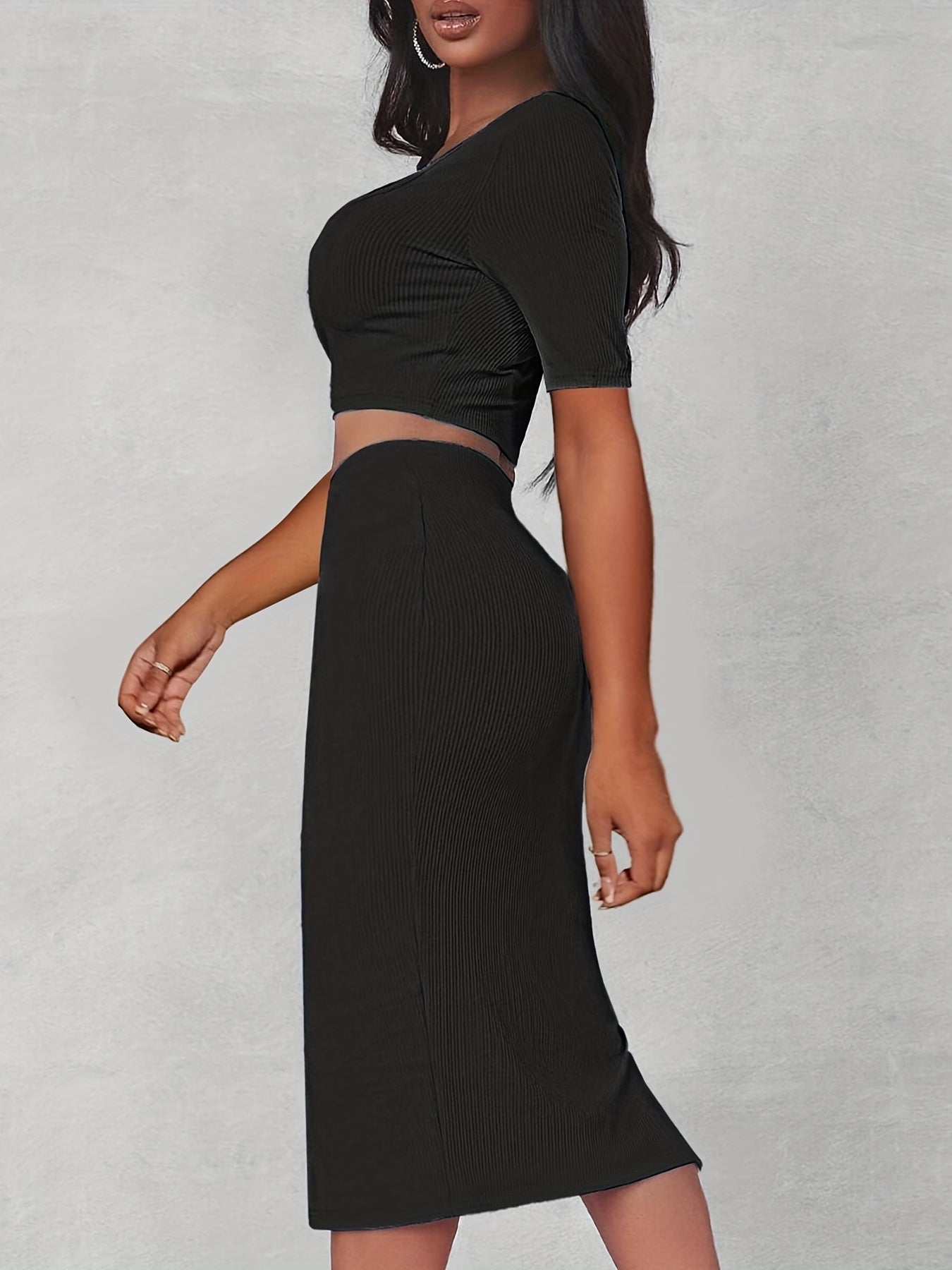 Set bestå ende av en crop top med utskärning och en passande kjol med slits