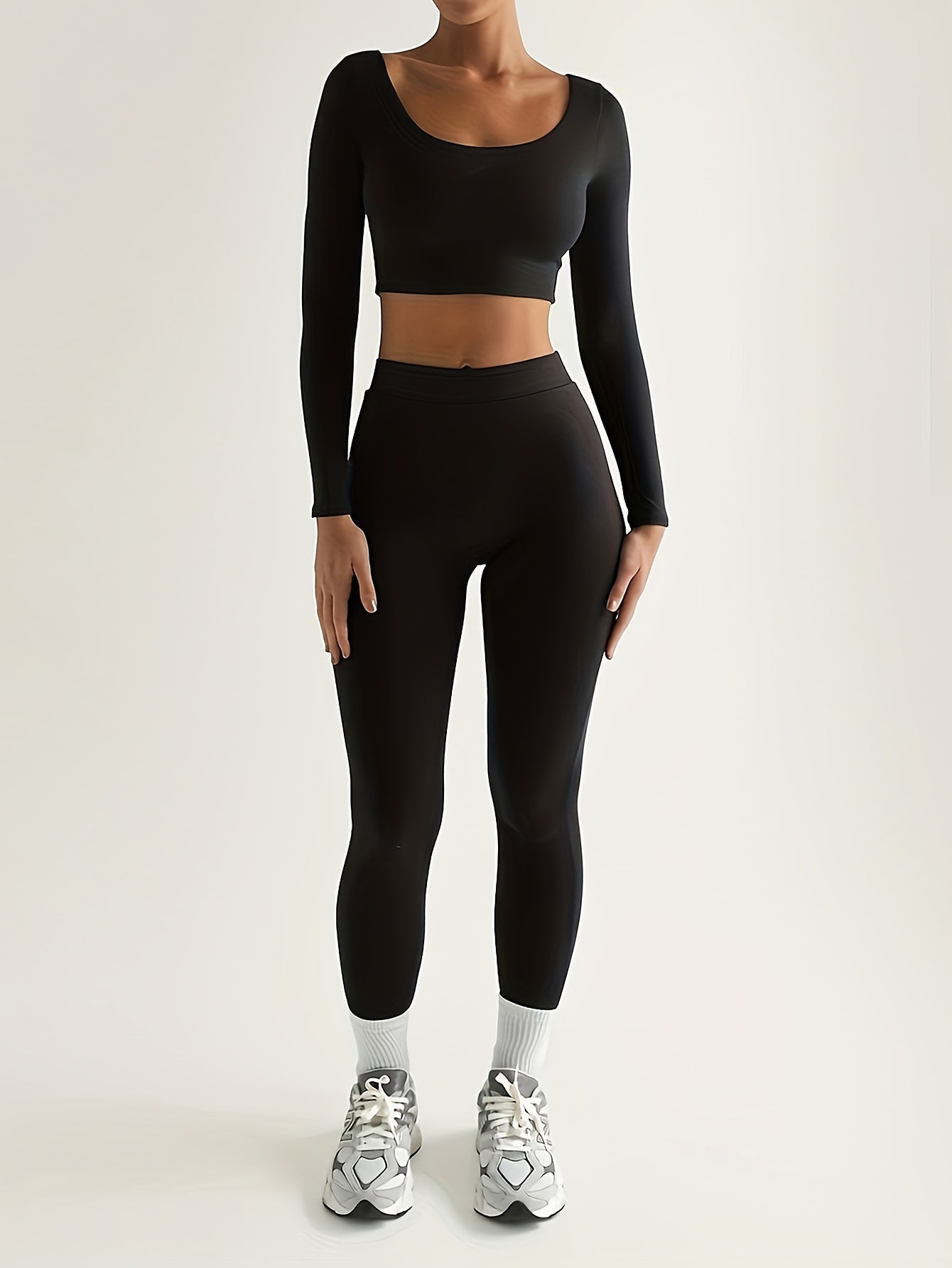 Sportset som bestå r av en lå ngärmad crop top och smala byxor med hög midja
