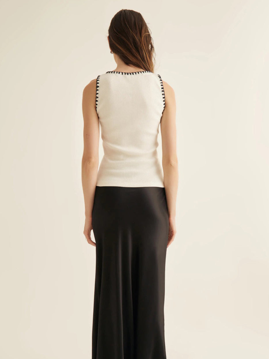 Vit minimalistisk topp med kontrasterande muddar