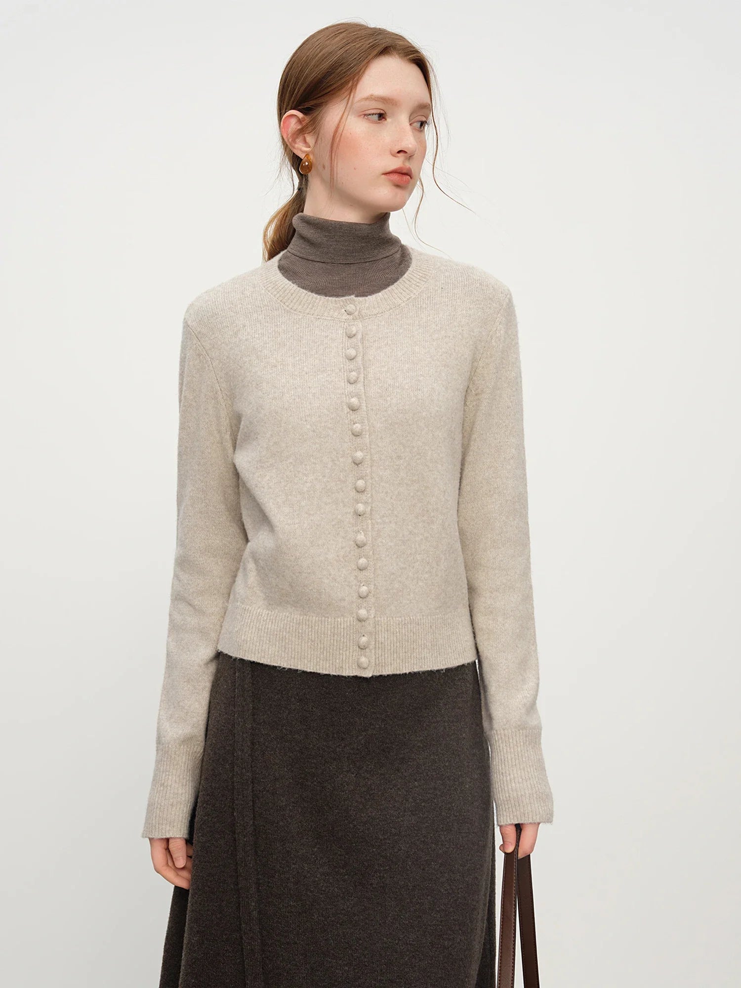 Stickad kofta i blandad stickning med ullknappar