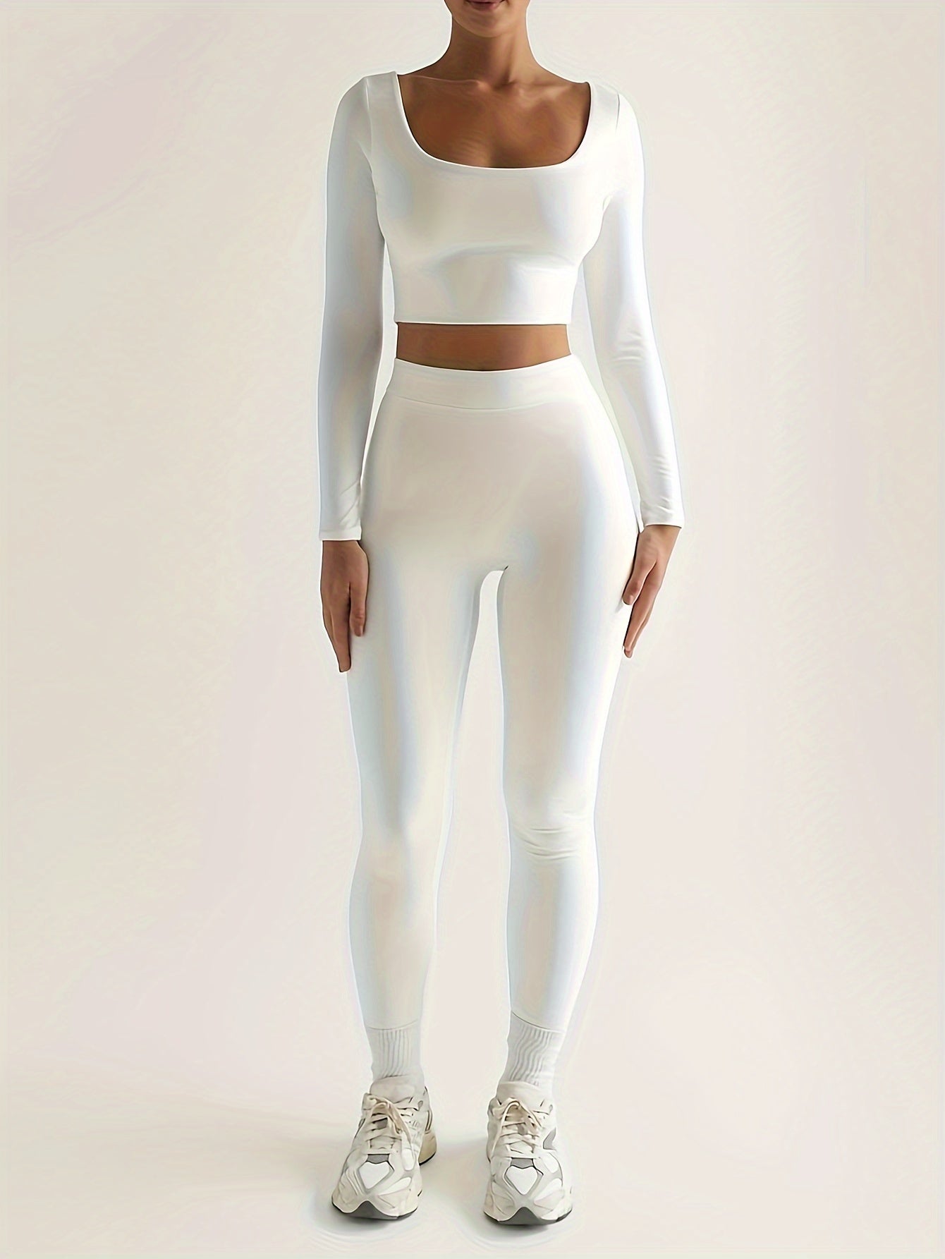 Sportset som bestå r av en lå ngärmad crop top och smala byxor med hög midja