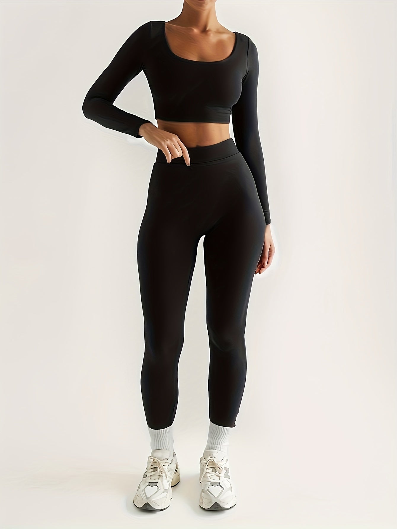 Sportset som bestå r av en lå ngärmad crop top och smala byxor med hög midja