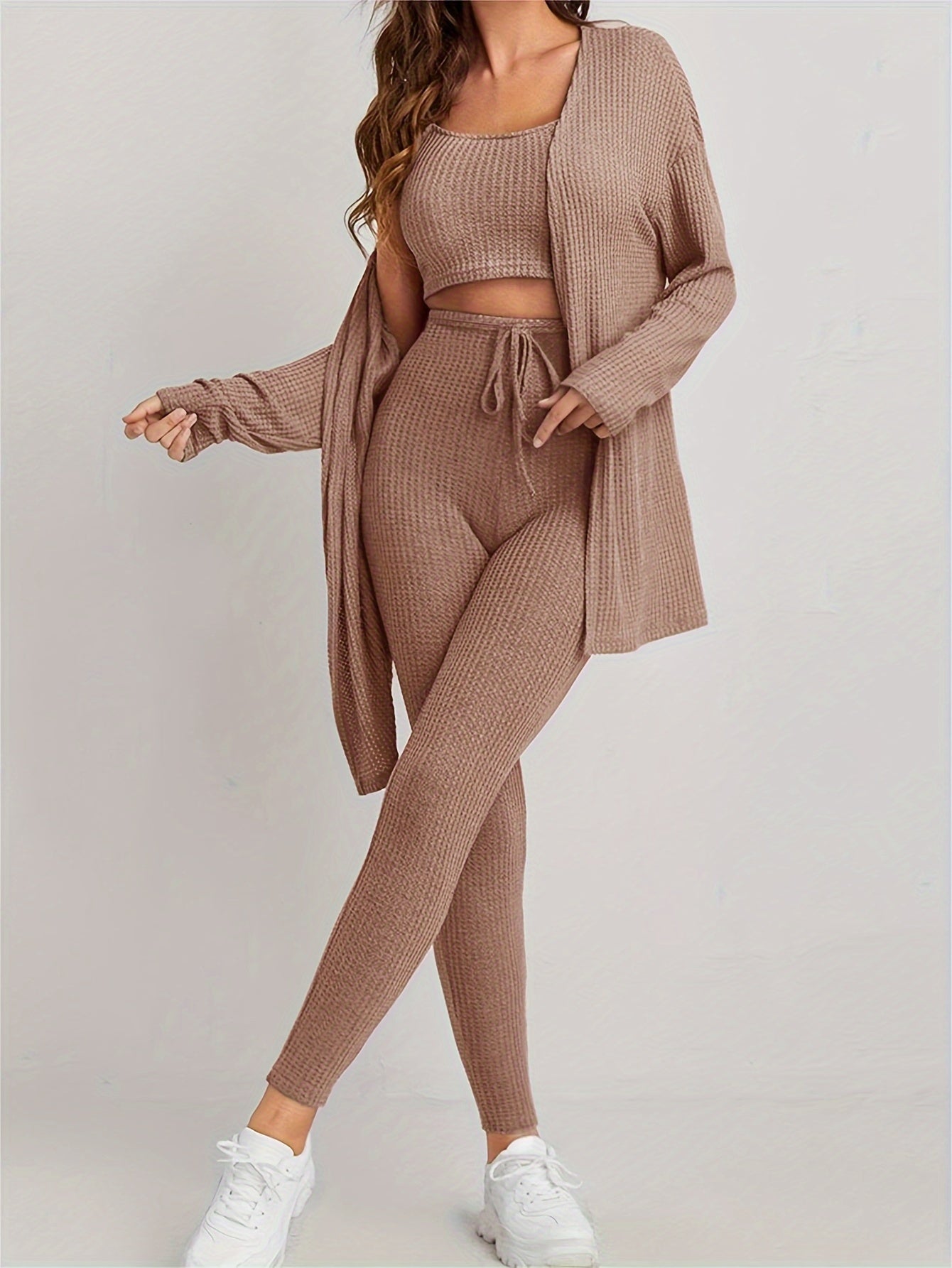 Set bestå ende av väst, cropped top och smala byxor med dragsko