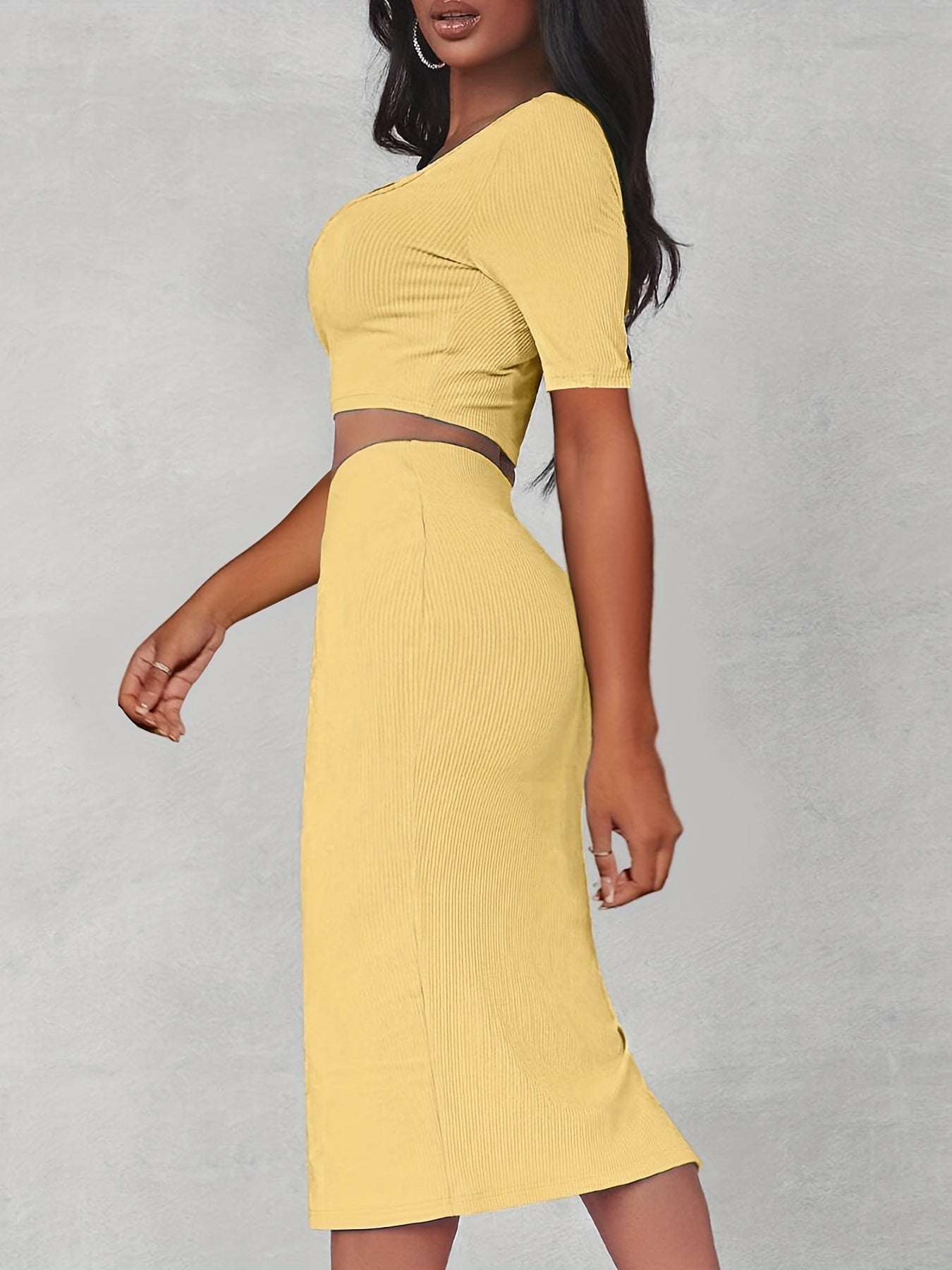 Set bestå ende av en crop top med utskärning och en passande kjol med slits