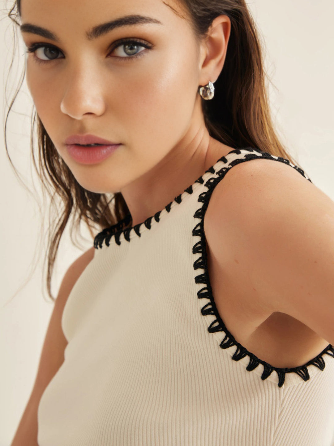 Vit minimalistisk topp med kontrasterande muddar