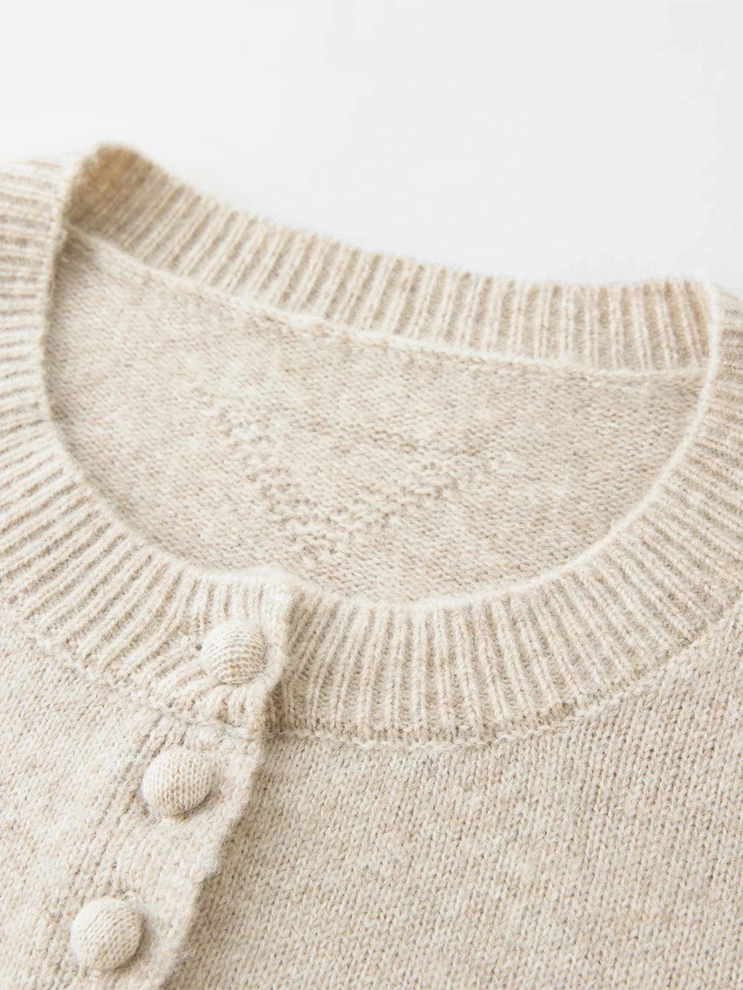 Stickad kofta i blandad stickning med ullknappar