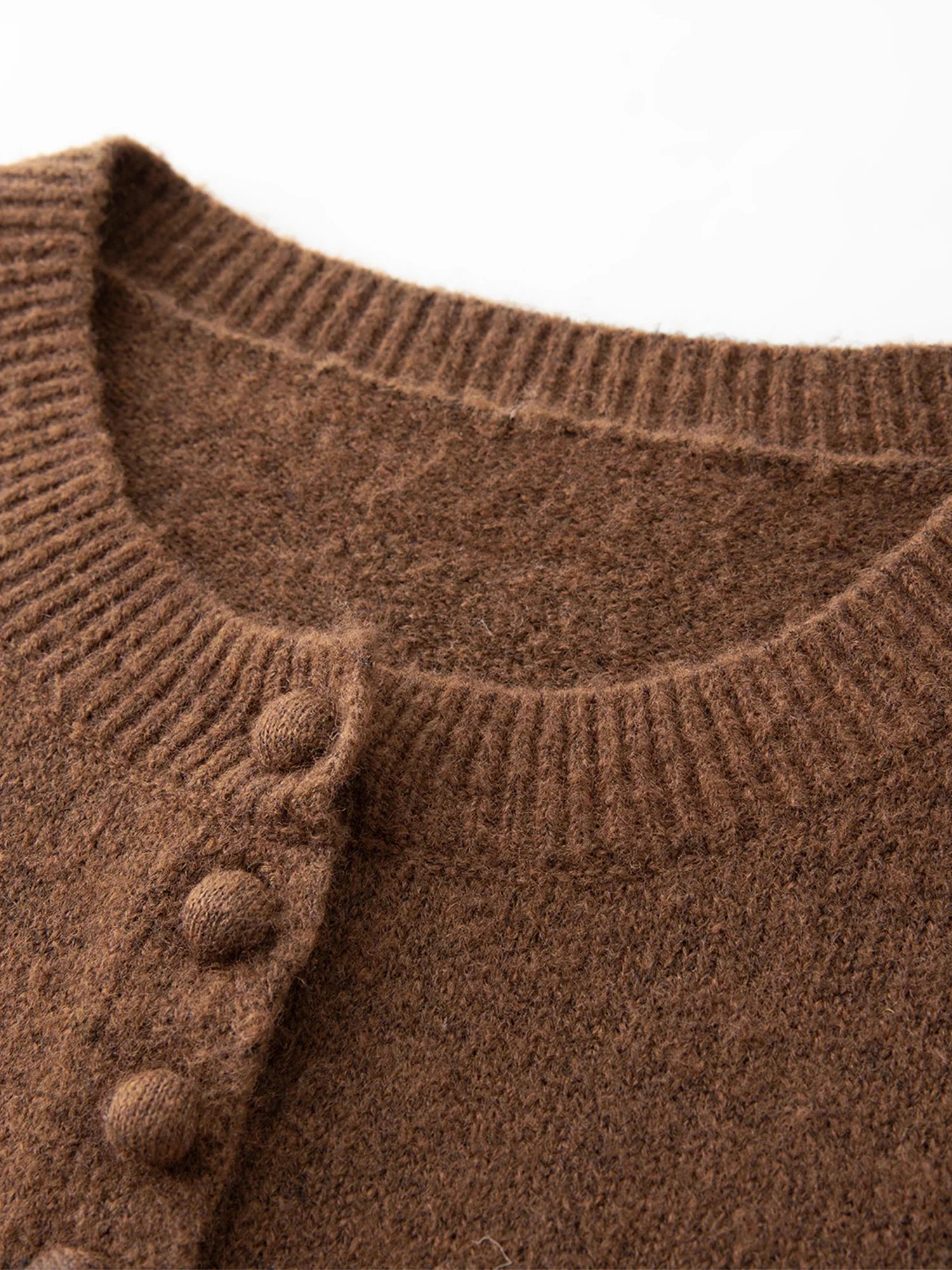 Stickad kofta i blandad stickning med ullknappar