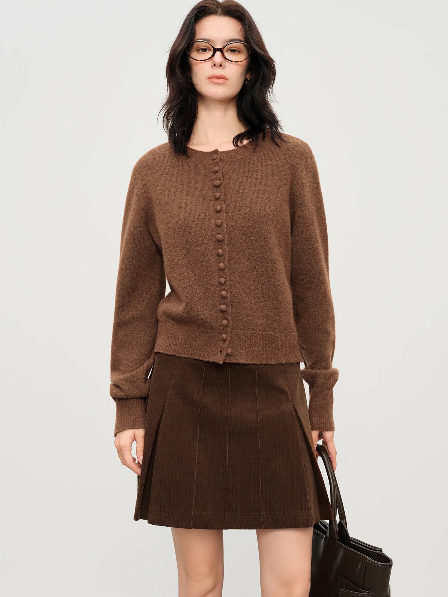 Stickad kofta i blandad stickning med ullknappar