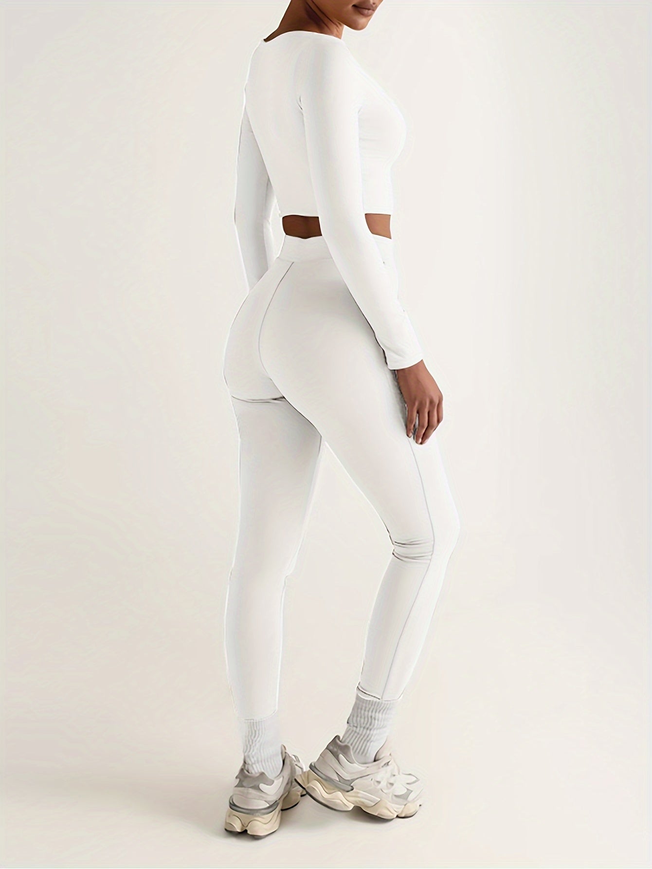Sportset som bestå r av en lå ngärmad crop top och smala byxor med hög midja